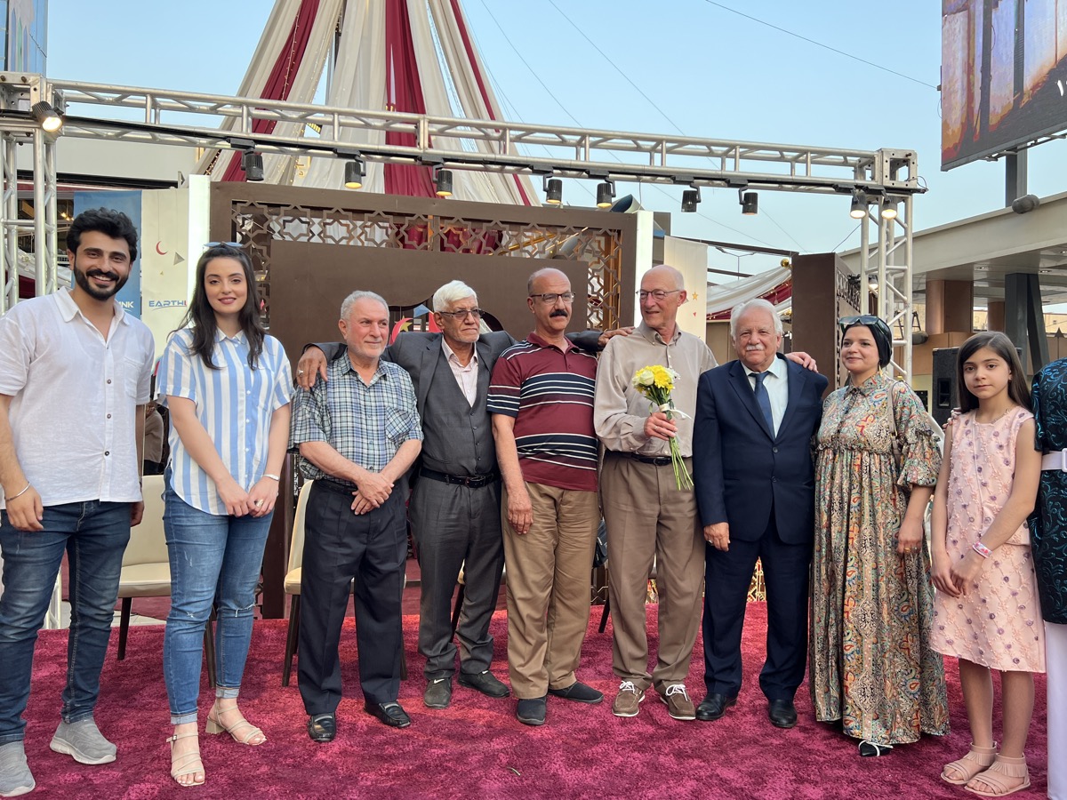 The film's subject holding flowers, surrounded by old and new friends on the celebration stage