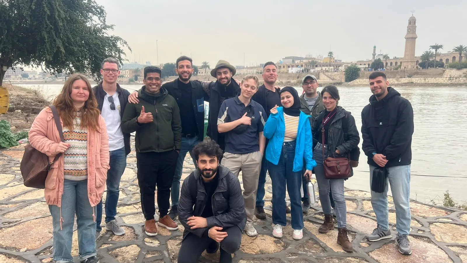 International travelers group photo along the Tigris riverbank in Baghdad