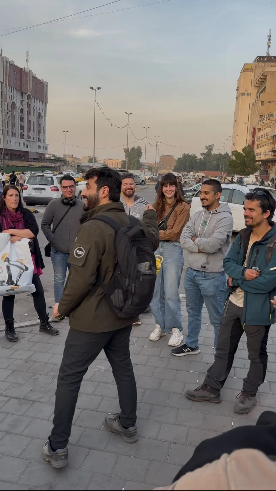 Baghdad Walking Tour group standing beneath a historic wooden shanashil balcony